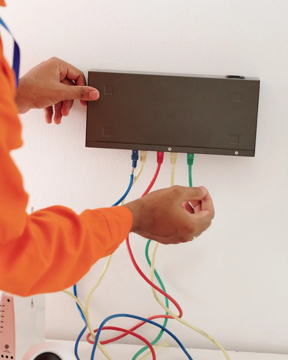 Tecnico che collega un dispositivo a parete in una casa